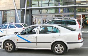 Taxi estacionado en el acceso a un centro comercial.