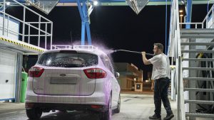 Cliente realizando limpieza exterior de coche en lavadero de coches en Málaga, ServiÁrea Málaga