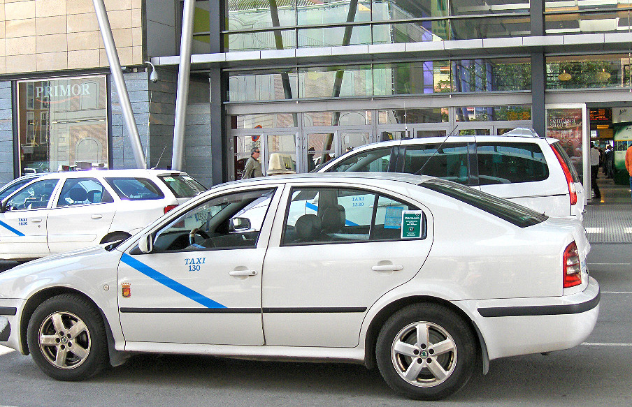 Taxi estacionado en el acceso a un centro comercial.